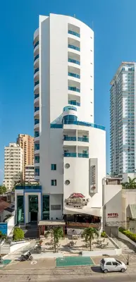 a large white building with a car parked in front of it at Hotel Atlantic Lux in Cartagena de Indias