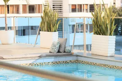 a pool with potted plants sitting next to a building at Hotel Atlantic Lux in Cartagena de Indias