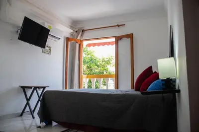 a bedroom with a bed with a television and a window at Casa Fanny in Cartagena de Indias