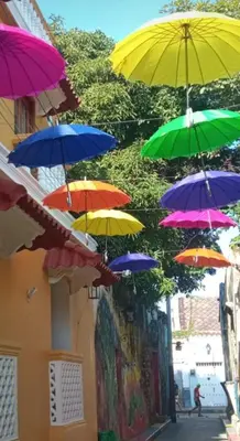 a bunch of colorful umbrellas hanging from a building at Casa Fanny in Cartagena de Indias
