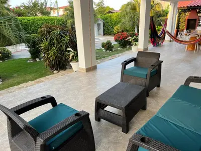 a patio with chairs and tables and a swing at Villa Las Marias in Santa Veronica