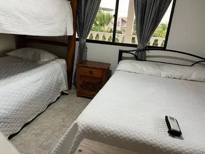 a bedroom with two beds and a window at Villa Las Marias in Santa Veronica