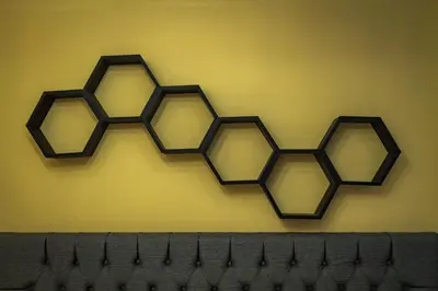 a yellow wall with four honeycomb shapes on it at Genesis Hotel in Sincelejo