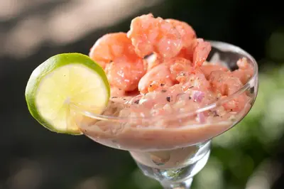 a glass of shrimp with a lime slice in it at Isla Tijereto in Isla Grande
