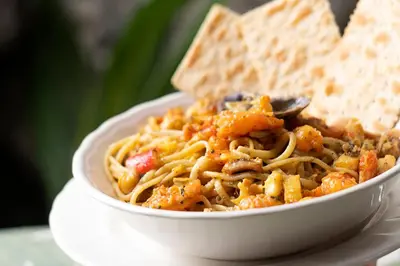 a bowl of pasta with a spoon and some bread at Isla Tijereto in Isla Grande