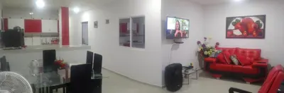 a living room with a red couch and a tv at La Roca Coveñas Apartamentos in Coveñas