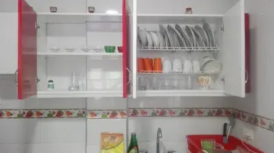 a kitchen cabinet with plates and dishes in it at La Roca Coveñas Apartamentos in Coveñas