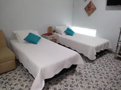 two beds sitting in a room with a window at Casa Anita in Cartagena de Indias