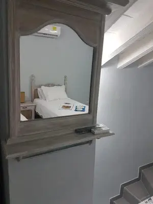 a mirror on a shelf in a room with a bed at Casa Anita in Cartagena de Indias