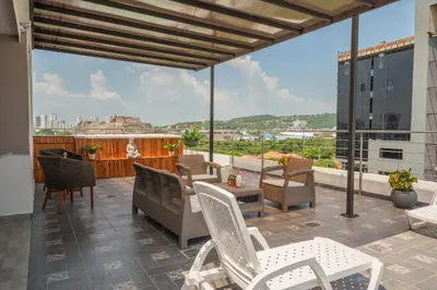 a balcony with chairs and tables and a view of the city at Bahia 79 Apartasuites Cerca al Centro in Cartagena de Indias