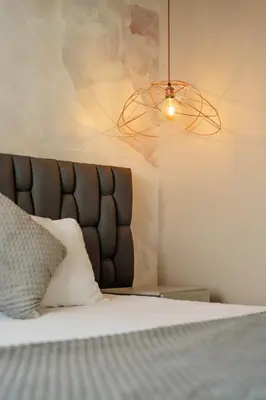 a bedroom with a bed with a black headboard and a light at Bahia 79 Apartasuites Cerca al Centro in Cartagena de Indias