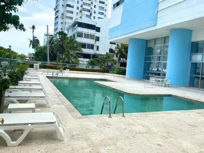 a swimming pool with lounge chairs and a building at Apartamento en Cartagena con Vista al Mar in Cartagena de Indias