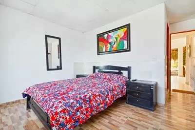 a bedroom with a bed and a dresser in it at Casa Hotel Nurandy in Cartagena de Indias