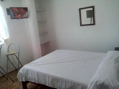 a bedroom with a white bed and a chair at Casa Hotel Nurandy in Cartagena de Indias