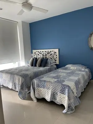 a bedroom with two beds and a blue wall at Apartamento Cartagena Morros Epic 25 in Cartagena de Indias