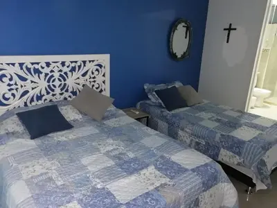 a bedroom with two beds and a cross on the wall at Apartamento Cartagena Morros Epic 25 in Cartagena de Indias