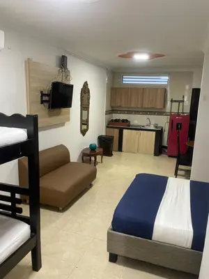 a bedroom with a bed and a couch and a kitchen at Alojamientos Cartagena Edificio Los Delfines in Cartagena de Indias