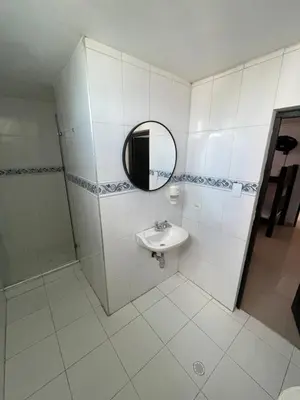 a white bathroom with a sink and a mirror at Alojamientos Cartagena Edificio Los Delfines in Cartagena de Indias