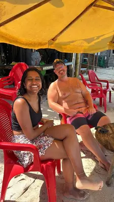 a man and a woman sitting in chairs on the beach at Tipiland baru la casa del mono in Playa Blanca