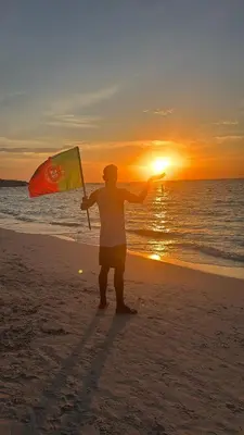 a man holding a kite on the beach at sunset at Tipiland baru la casa del mono in Playa Blanca