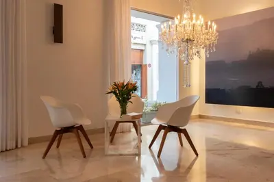 a dining room with white chairs and a chandelier at Delirio Hotel in Cartagena de Indias