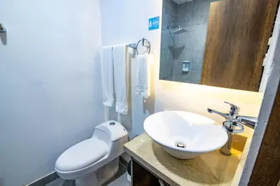 a bathroom with a white toilet and a sink at Hotel Amoek in Cartagena de Indias