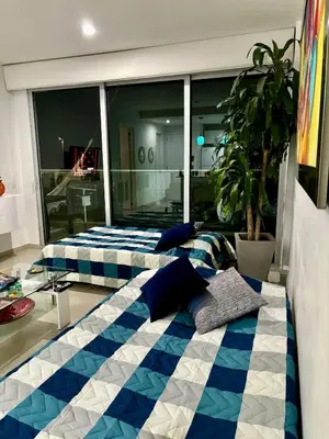 a bedroom with two beds with blue and white sheets at Apartamento Confort Frente a la Playa en Cartagena! in Cartagena de Indias