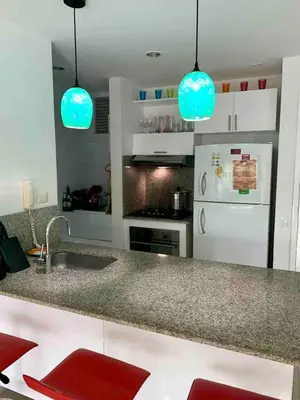 a kitchen with blue lights above a kitchen counter at Apartamento Confort Frente a la Playa en Cartagena! in Cartagena de Indias