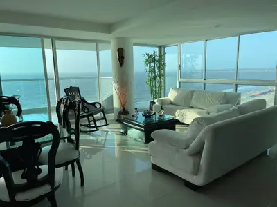 a living room with a couch and a table and chairs at Cartagena Beach Front Apartments in Cartagena de Indias