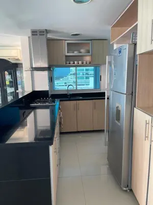 a kitchen with a stainless steel refrigerator and cabinets at Cartagena Beach Front Apartments in Cartagena de Indias