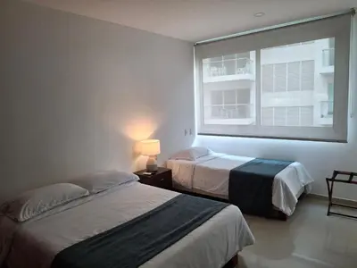two beds in a room with a window at Cartagena Beach Condo - 1400 sq. Ft. (130 m2) in Cartagena de Indias