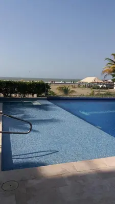 a swimming pool with a hose in front of the ocean at Cartagena Beach Condo - 1400 sq. Ft. (130 m2) in Cartagena de Indias