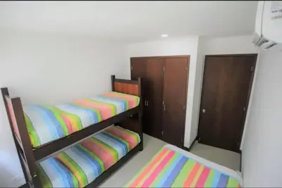 two bunk beds in a room with colorful sheets at Edificio acceso directo al mar primera linea de playa 2 habitaciones in Cartagena de Indias