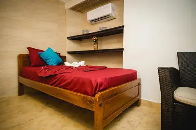 a bedroom with a bed with red sheets and blue pillows at Hotel El Viajero Centro in Cartagena de Indias