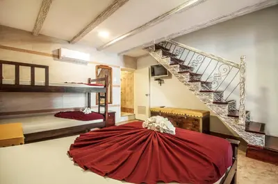 a room with a red table and a staircase at Hotel El Viajero Centro in Cartagena de Indias