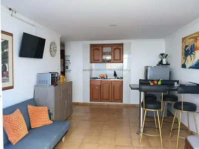a living room with a blue couch and a kitchen at Apartamento 1101 Edificio Nuevo Conquistador in Cartagena de Indias