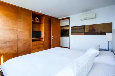 a bedroom with a white bed and wooden cabinets at Palmetto Penthouse Deluxe Beautiful view and sunset floor 39 in Cartagena de Indias
