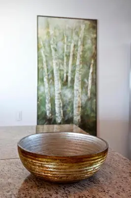 a wooden bowl sitting on a table in front of a painting at Palmetto Penthouse Deluxe Beautiful view and sunset floor 39 in Cartagena de Indias