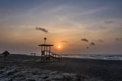 a lifeguard stand on the beach at sunset at Hotel Arena Beach Cartagena in Cartagena de Indias