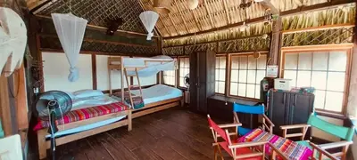 a room with two bunk beds and two chairs at Casa Akira- Rincón del Mar in San Onofre