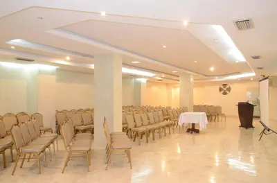a room with a bunch of chairs and a podium at Hotel Intersuites in Barranquilla
