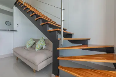 a living room with a couch under a staircase at MURANO ELITE NEW OCEAN FRONT DUPLEx in Cartagena de Indias