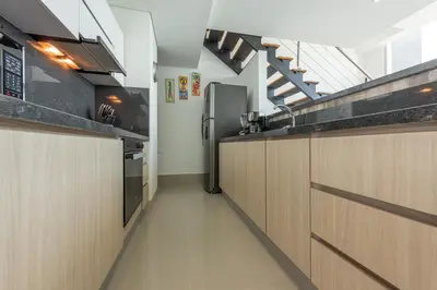 a kitchen with wooden cabinets and stairs in a room at MURANO ELITE NEW OCEAN FRONT DUPLEx in Cartagena de Indias