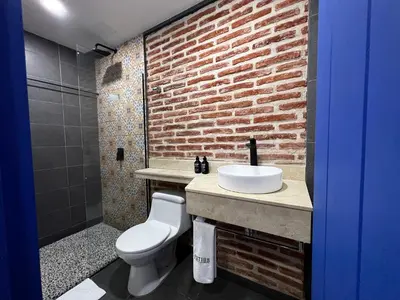 a bathroom with a white sink and a brick wall at Los Patios Hostel Cartagena in Cartagena de Indias