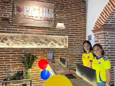 two girls standing next to a table with laptops at Los Patios Hostel Cartagena in Cartagena de Indias