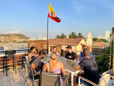 a group of people sitting at a table on a roof at Los Patios Hostel Cartagena in Cartagena de Indias