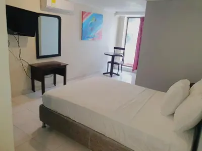 a bedroom with a bed and a desk and a mirror at Hotel Puerta de Oro in Barranquilla