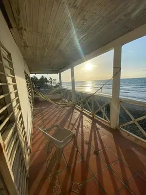 a balcony with a chair and the ocean at Cabaña Playa De Los Venados in San Bernardo del Viento