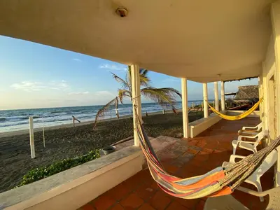 a hammock on the porch of a house overlooking the beach at Cabaña Playa De Los Venados in San Bernardo del Viento