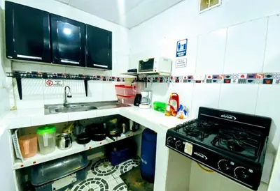 a small kitchen with a stove and a sink at Oasis de Tolú in Tolú